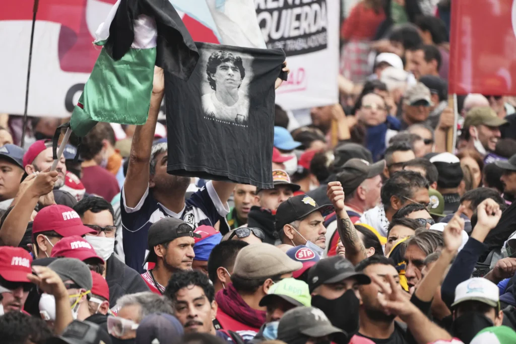 Pendemo Argentina mengangkat kaos Diego Maradona saat aksi protes di Buenos Aires