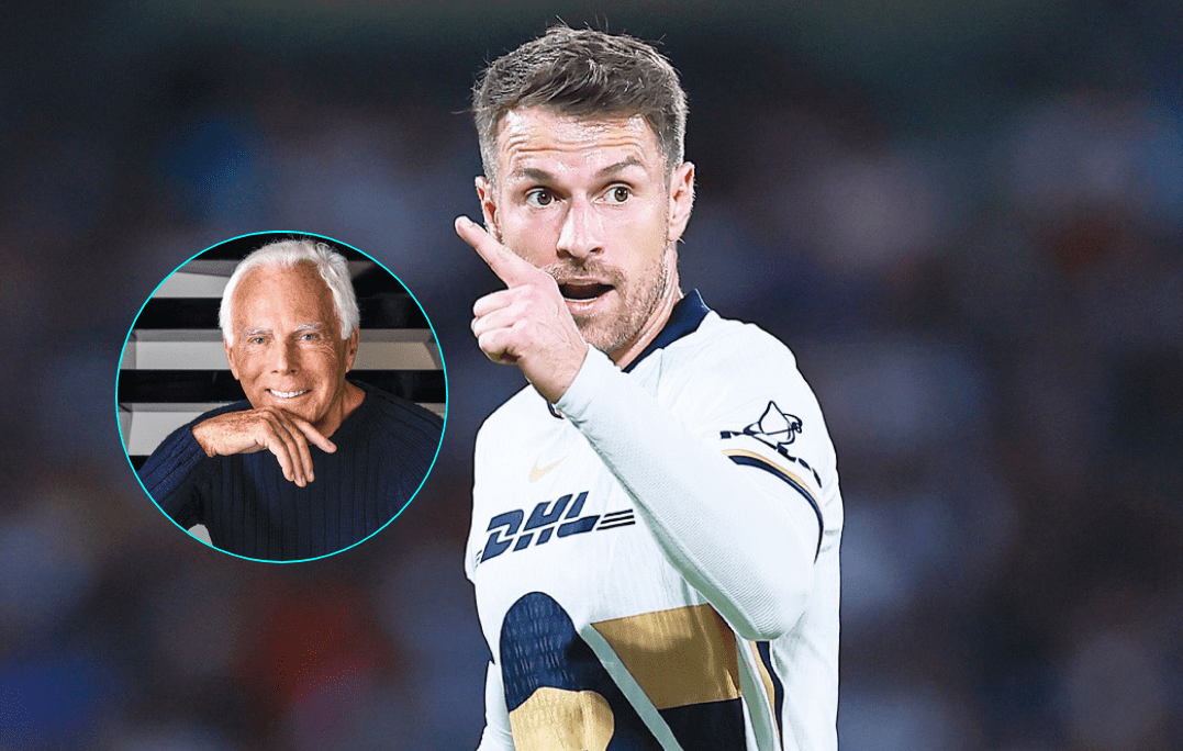 aaron-ramsey-giorgio-armani-curse Aaron Ramsey menunjuk ke depan dengan inset foto Giorgio Armani, setelah kabar wafatnya desainer Italia dikaitkan dengan kutukan gol Ramsey.
