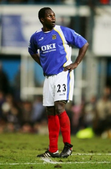 Emmanuel Olisadebe mengenakan jersey Portsmouth dalam pertandingan Premier League.