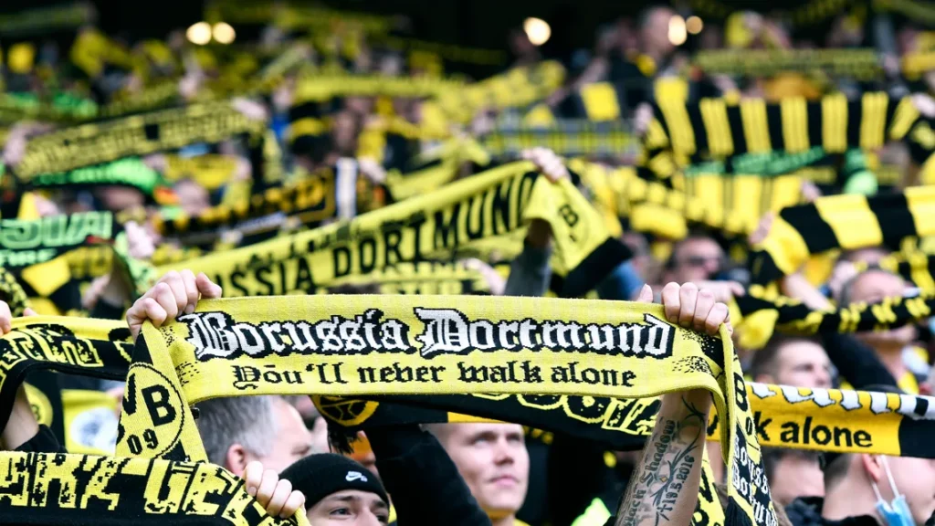 Fans Borussia Dortmund mengangkat syal bertuliskan You'll Never Walk Alone di Signal Iduna Park sebelum kick-off pertandingan Bundesliga.