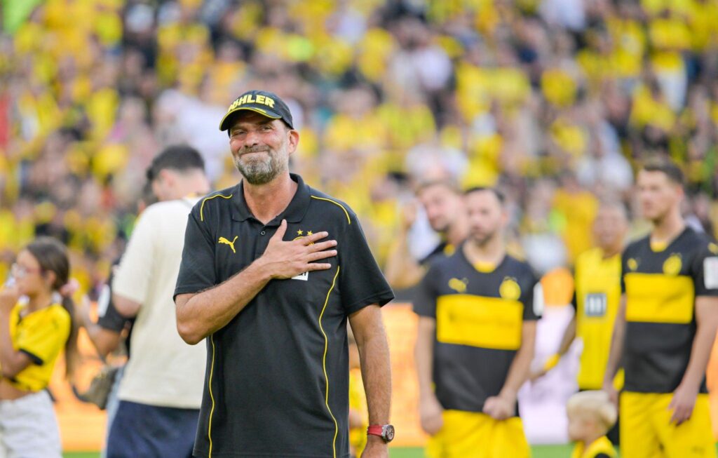 Jurgen Klopp meletakkan tangan di dada sebagai tanda haru saat perpisahan di Signal Iduna Park, simbol eratnya hubungan Klopp dengan Borussia Dortmund dan para pendukungnya.