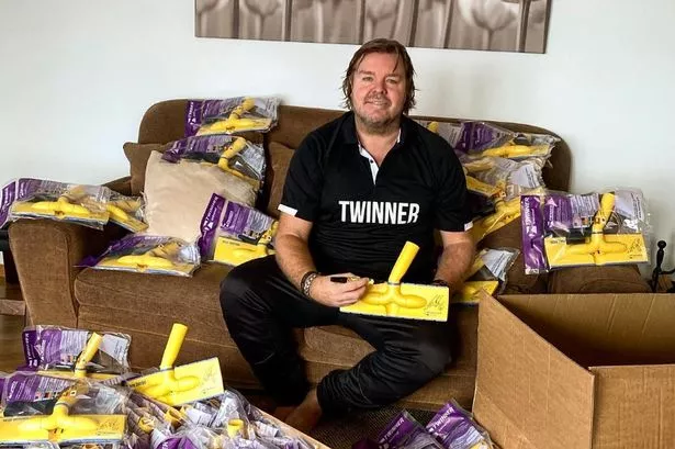 Tomas Brolin duduk di sofa dikelilingi produk vacuum cleaner Twinner yang ia jual