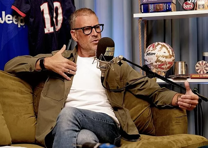 Clattenburg berbicara di studio podcast sepak bola dengan mikrofon di depannya.