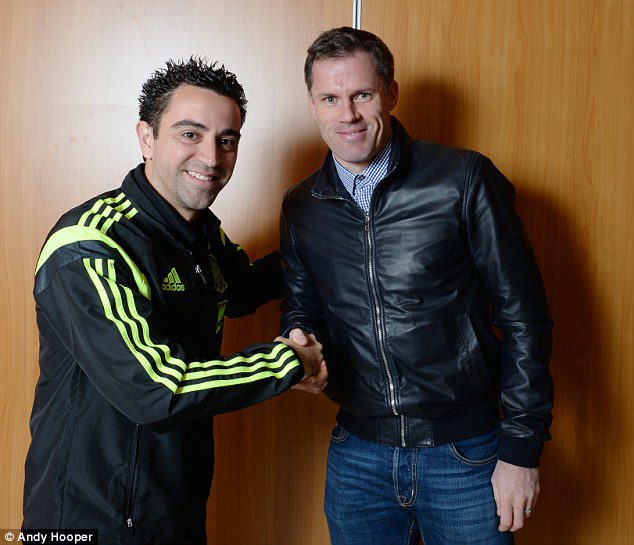 Xavi Hernandez berjabat tangan dengan Jamie Carragher dalam sebuah pertemuan setelah pensiun dari sepak bola.