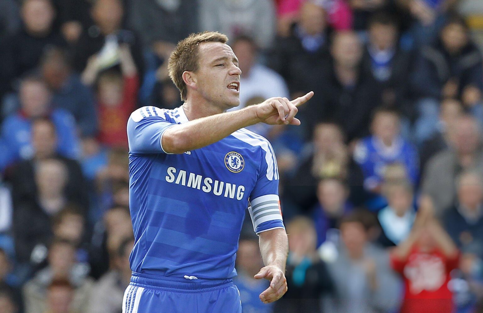 John Terry saat menjadi kapten Chelsea sedang memberi instruksi kepada rekan setim di lapangan.