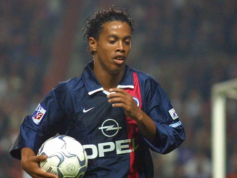 Ronaldinho saat bermain untuk PSG, menolak kepindahan ke Manchester United karena faktor cuaca Inggris.