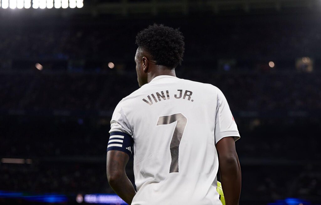 Vinicius Junior mengenakan jersey Real Madrid bernomor 7 di stadion, masuk jajaran pemain dengan penjualan jersey tertinggi 2025.